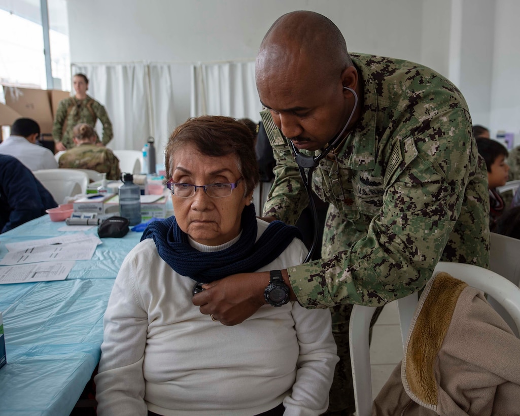 A nurse examines a patient.