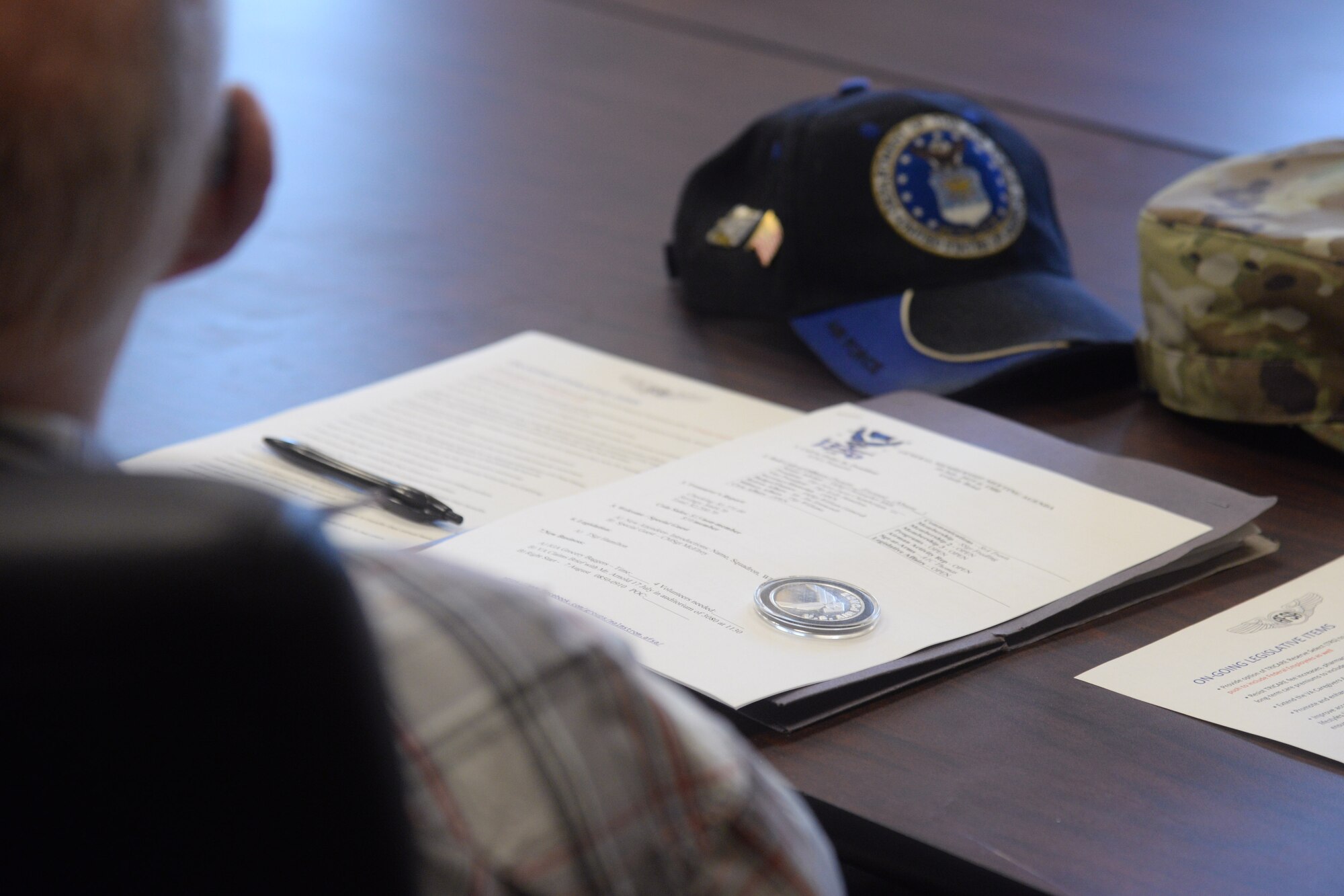 A document is displayed with an Air Force coin during an Air Force Sergeants Association meeting July 10, 2019, at Malmstrom Air Force Base, Mont.