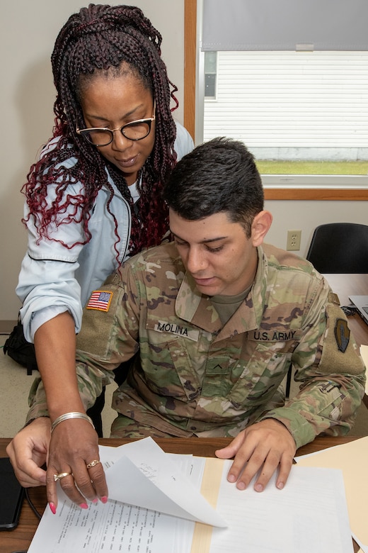 Johnjulyn Newman, Defense Finance and Accounting Service Defense Military Pay Office military pay technician, points out additional information to U.S. Army Pvt. Josue Molina, financial management technician, during Diamond Saber 2019 at Fort McCoy, Wis., June 28, 2019. DFAS brought realism to the Army’s largest financial management exercise through live coding of actual Soldier’s pay. (U.S. Army photo by Mark R. W. Orders-Woempner)