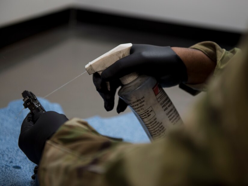 Staff Sgt. Rossitor Alexander, an instructor assigned to the 628th Security Forces Squadron Combat Arms Training and Maintenance flight, sprays an M9 pistol with a cleaning solution after firing it at Joint Base Charleston, S.C. July 1, 2019. CATM facilitates readiness by equipping Airmen with the knowledge and skills to use weapons properly, and provides support to local and regional military branches. CATM instructors qualify for the weapons annually to maintain proficiency.