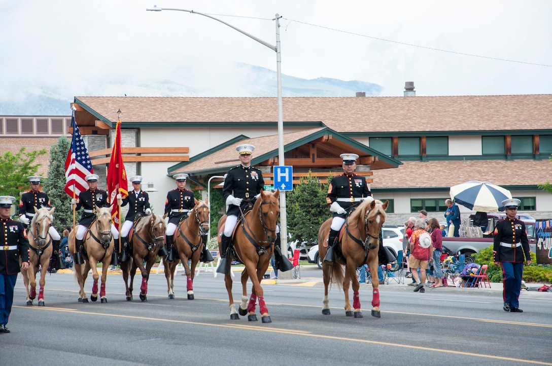 Colonel Craig C. Clemans, commanding officer, Marine Corps Logistics Base Barstow, and Sgt. Major Sergio MartinezRuiz, base sergeant major, lead the Marine Corps Mounted Color Guard during the Cody Rodeo Stampede Parade held in Cody Wyoming, July 3.