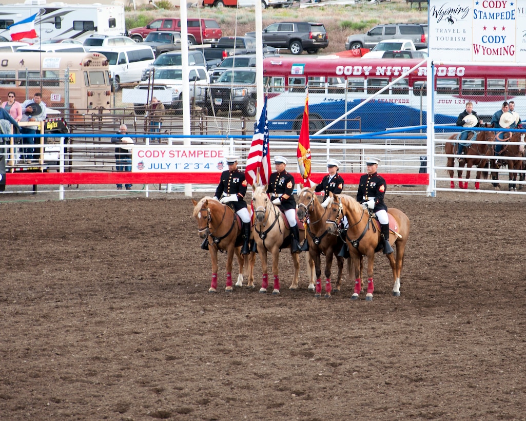 The Marine Corps Mounted presents the colors at center arena during the Cody, Wyo., Rodeo Stampede July 4.