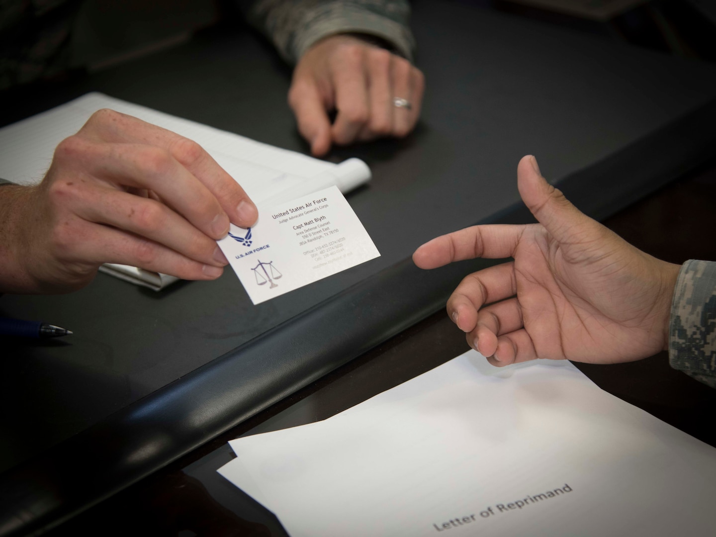 Capt. Matthew Blyth, a Defense Attorney with the Air Force Legal Operations Agency/Area Defense Council hands a troubled Airman his official business card July 10, 2019 at the Joint Base San Antonio-Randolph ADC. The ADC is a full-spectrum resource, implemented in 1974, to help Airmen through the lowest level paperwork, such as a letter of counseling or a letter of reprimand, up to the most serious court martial cases. (U.S. Air Force photo by: Airman 1st Class Shelby Pruitt)