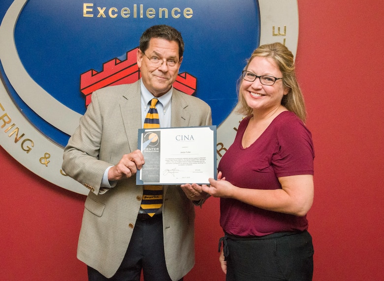 Roy W. Malone Jr., the director of the Office of Center Operations at NASA’s Marshall Space Flight Center, presents the “Capturing It Now Award” to Jaclyn Fuller, project manager in the Facility Reduction Program at the U.S. Army Engineering and Support Center, Huntsville, June 17, 2019. Malone visited Huntsville Center to personally recognize Fuller for her work as project manager for the NASA Santa Susana Field Laboratory demolition project in southern California.