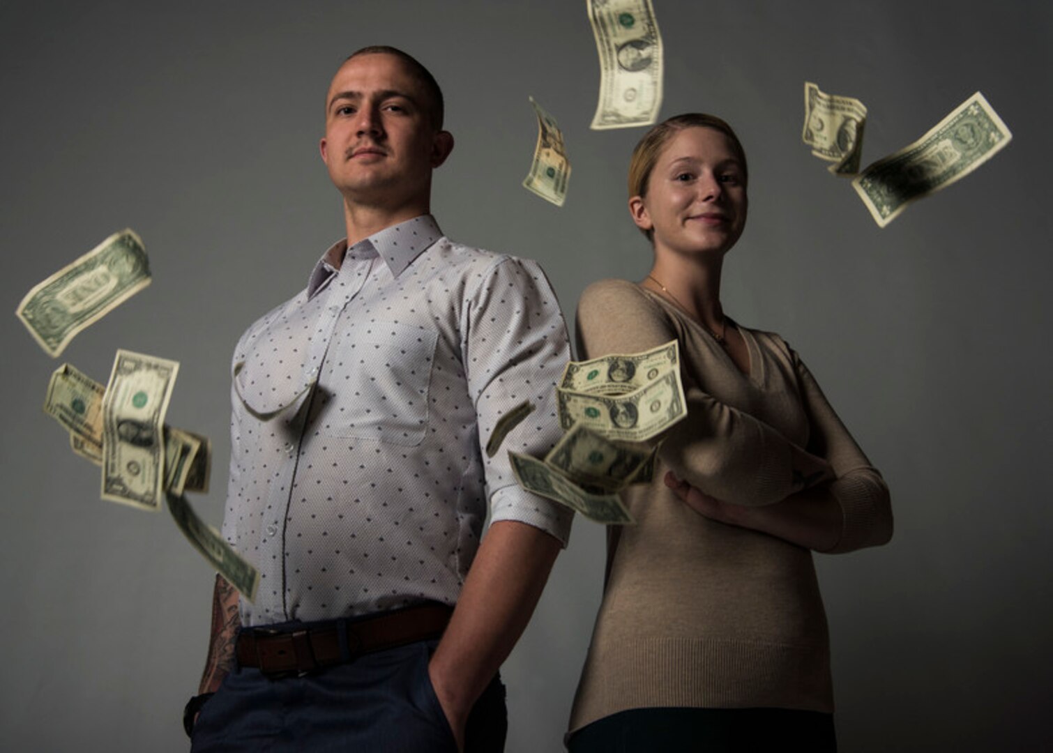 Senior Airman Clayton Wear and Airman 1st Class Hanah Abercrombie, 30th Space Wing Public Affairs photojournalists ,pose for a photo as money falls down April 3, 2019, at Vandenberg Air Force Base, Calif.