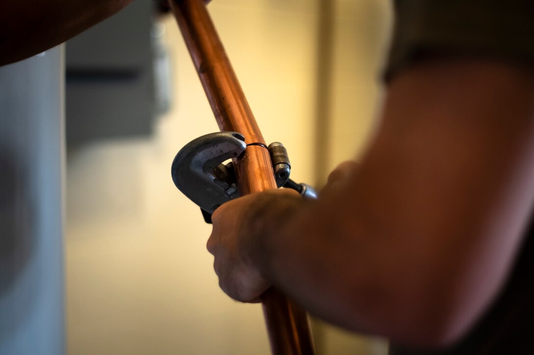 Staff Sgt. Joseph Dickerson, 23d Civil Engineer Squadron (CES) water and fuel systems maintenance craftsman, cuts a copper pipe to a fitting, July 2, 2019, at Moody Air Force Base, Ga. Airmen from the 23d CES Water and Fuels Systems Maintenance are on-call 24/7 to sustain and maintain the base, water, sewer and gas lines and upkeep of the 696 facilities with water and fuel infrastructure. (U.S. Air Force photo by Airman 1st Class Taryn Butler)