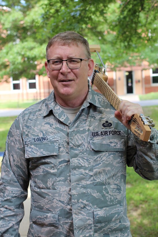 Master Sgt. Tony Loving, 932nd Force Support Squadron personnel systems, poses for a photo with his guitar, July 10, 2019, Scott Air Force Base, Illinois. He has witnessed many unit changes, as well as being involved in making music after work. Loving has helped on improvement within military processes during the day.  (U.S. Air Force photo by Lt. Col. Stan Paregien)