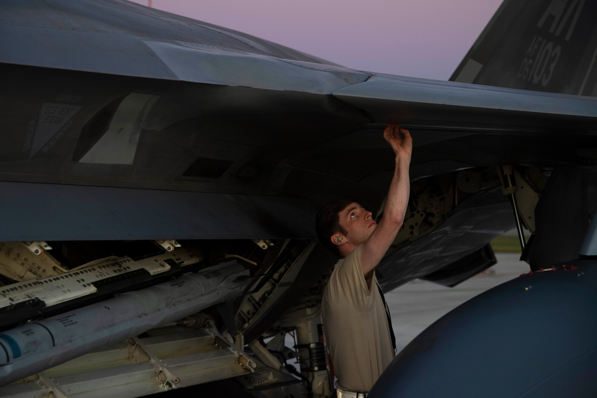 An Airman assigned to Joint Base Elmendorf-Richardson, Alaska, performs regular maintenance on U.S. Air Force F-22 Raptors after they arrive July 9, to Royal Australian Air Force Base Amberley, Australia, in support of Talisman Sabre 19. Talisman Sabre is a bilateral combined Australian and United States training activity designed to improve interoperability increase combat readiness. (U.S. Air Force photo by Senior Airman Elora J. Martinez)