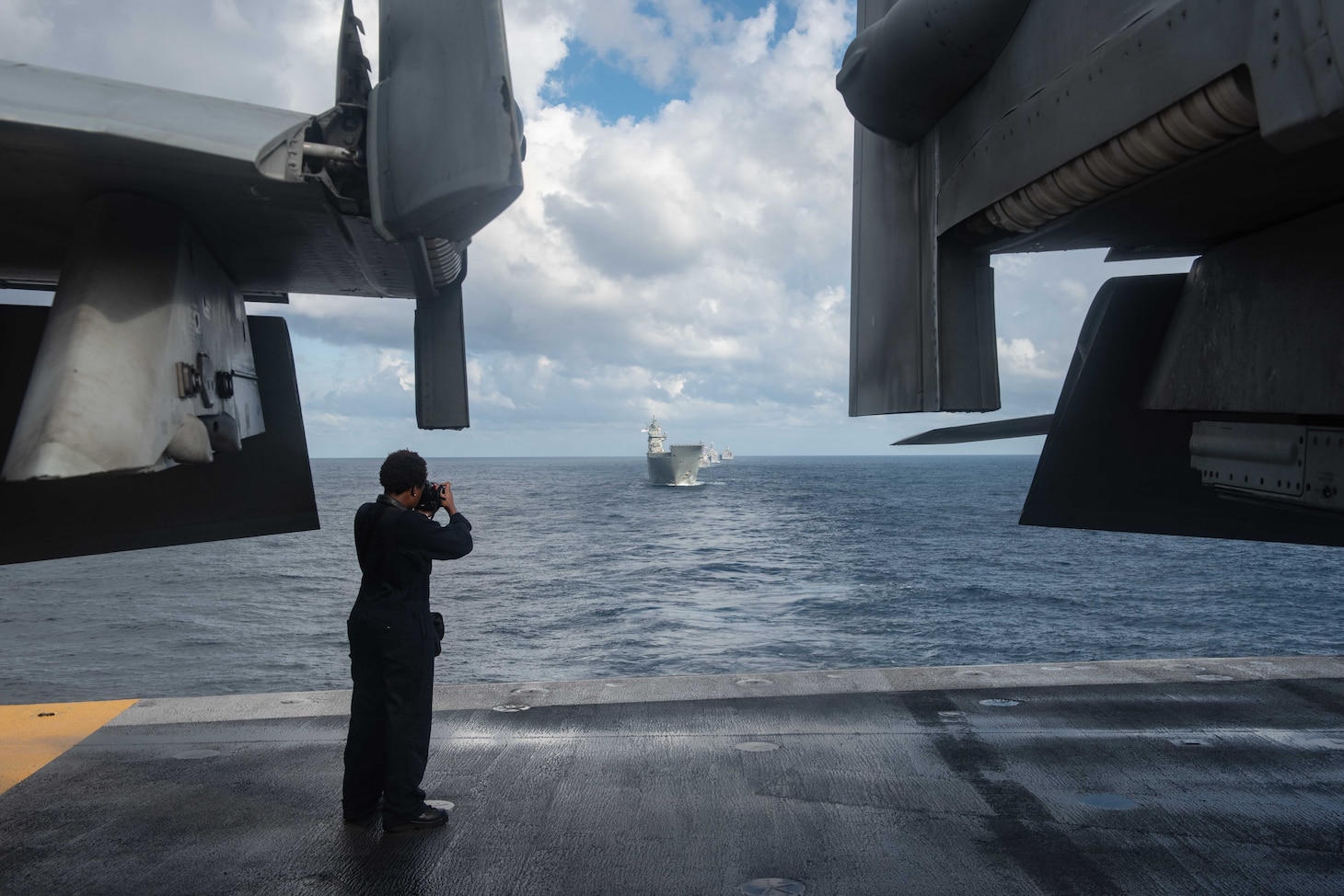 CORAL SEA (July 11, 2019) Mass Communication Specialist 2nd Class Tyra Campbell, from Philadelphia, photographs the Royal Australian Navy’s HMAS Canberra (L 02), as they sail in formation during Talisman Sabre 2019 on the flight deck of the Navy’s forward-deployed aircraft carrier USS Ronald Reagan (CVN 76). Talisman Sabre 2019 illustrates the closeness of the Australian and U.S. alliance and the strength of the military-to-military relationship. This is the eighth iteration of this exercise.