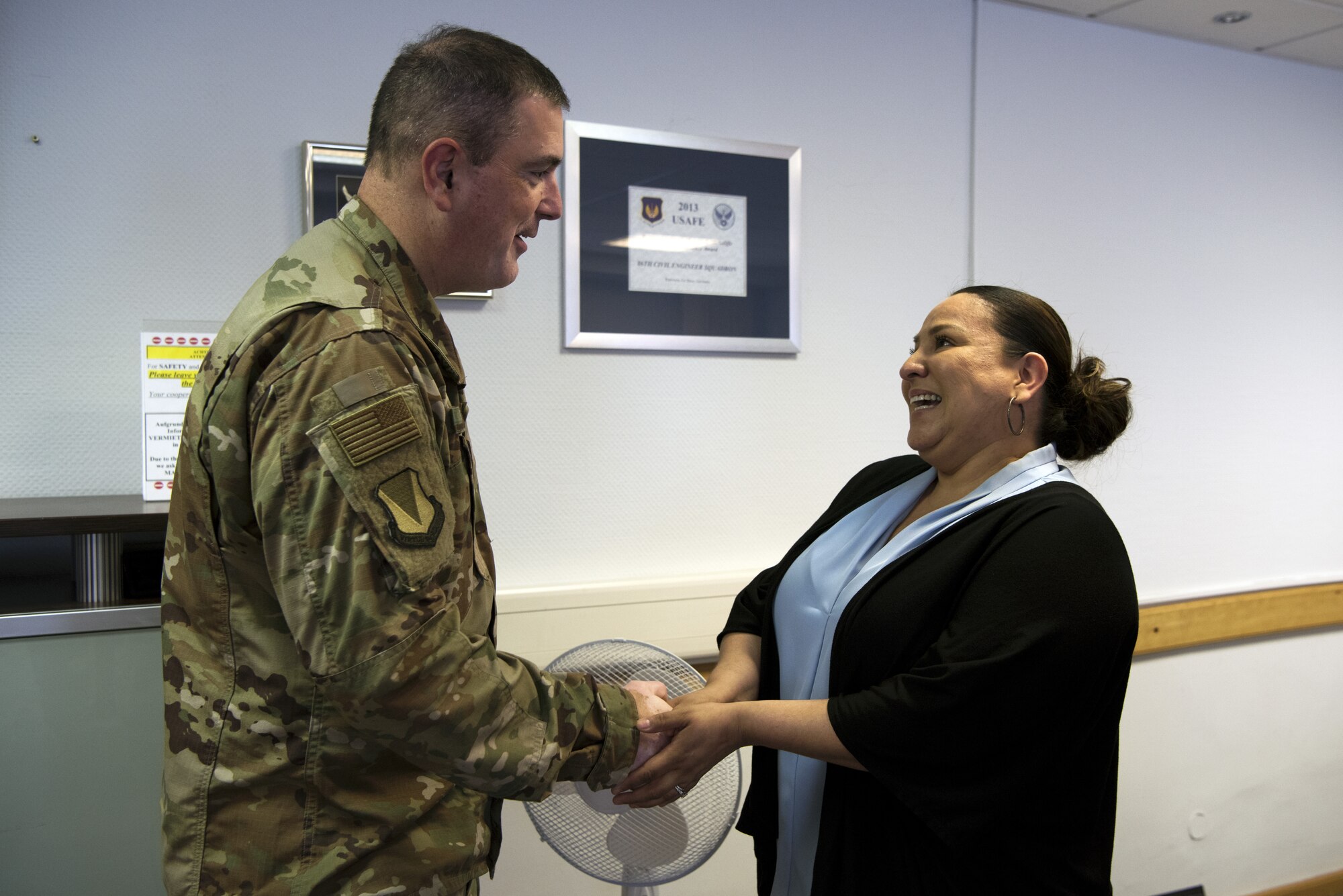 U.S. Air Force Brig. Gen. Mark R. August coins Alinka Perkins, KMC housing office receptionist, Vogelweh Military Complex, Germany, July 10, 2019. Perkins was recoginzed for her ourtstanding customer service.