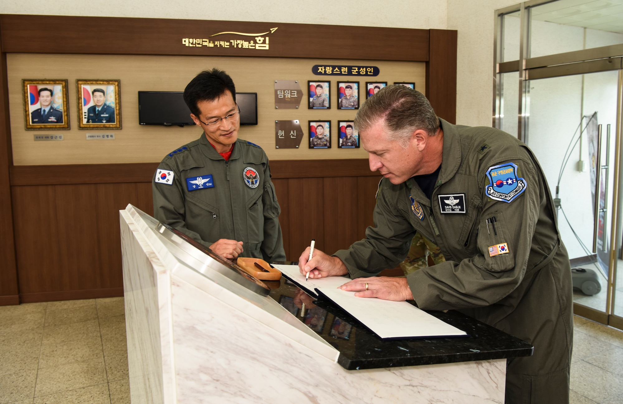 U.S. Air Force Brig. Gen. David Eaglin (right), 7th Air Force vice commander, signs a guest book at the 38th Fighter Group headquarters at Kunsan Air Base, Republic of Korea, July 12, 2019. Eaglin visited Kunsan and Republic of Korea Air Force’s 38th FG to introduce himself and strengthen the partnership between the U.S. and ROK. (U.S. Air Force photo by Staff Sgt. Joshua Edwards)