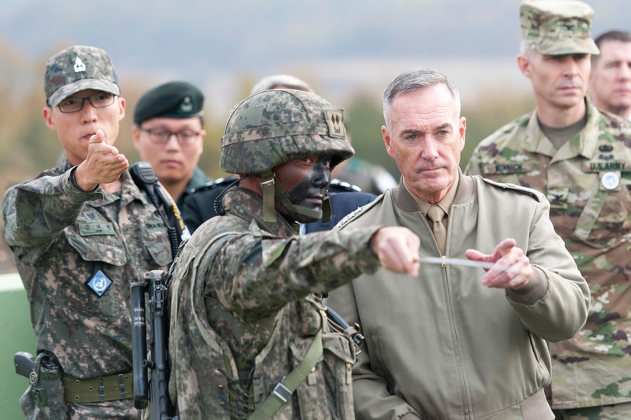 Soldier points out military features to general.