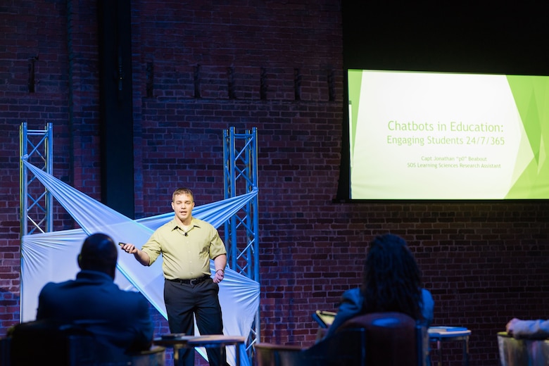 Captain Jonathan Beabout, a former Squadron Officer School student research assistant, pitches his idea for leveraging chatbot technology across Air Education and Training Command educational platforms at the MGMWERX Pitch Night, May 21, 2019, Montgomery, Alabama. The captain, the chief of weapons and tactics at Lackland AFB, Texas, developed his idea while taking SOS’s Air University Advanced Research Elective.