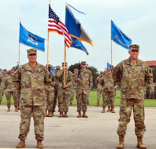 Col. Ingrid Parker (left), 470th Military Intelligence Brigade outgoing commander, and Col. Daniel Allen, 470th MI Brigade incoming commander, stand at attention during the brigade’s change of command ceremony at the MacArthur Parade Field at Joint Base San Antonio-Fort Sam Houston July 9.