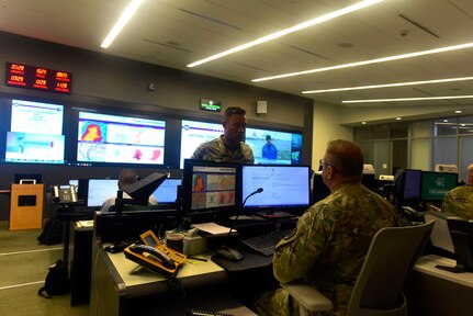 Army Maj. Frank Quintana, with the New York Army National Guard, talks with his team chief inside the National Guard Coordination Center in Arlington, Virginia, July 12, 2019. Quintana is serving as a situational analyst at the NGCC during the National Guard’s response to Tropical Storm Barry.