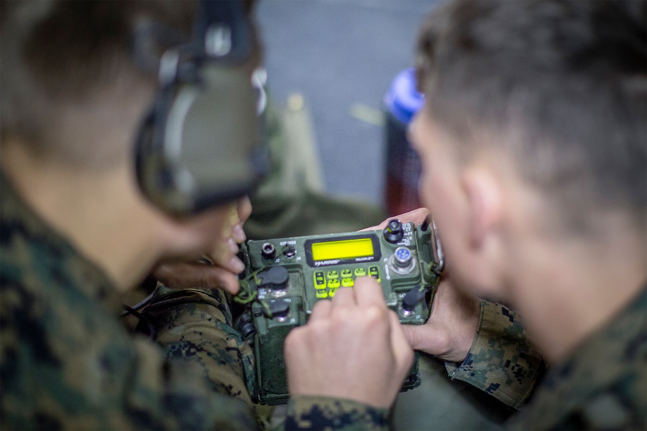 Marines type on a tactical radio keypad with a lighted display.