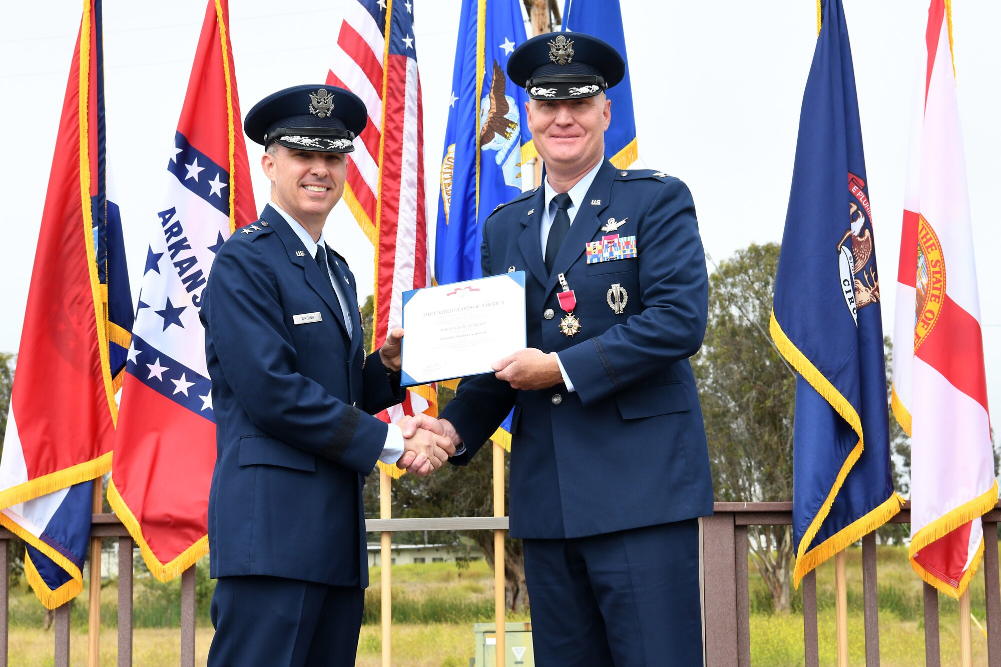 Maj. Gen. Stephen N. Whiting, 14th Air Force commander and Joint Force Space Component Command deputy commander, presents Col. Michael S. Hough, outgoing 30th Space Wing commander, with an award during a change of command ceremony July 12, 2019, at Vandenberg Air Force Base, Calif.