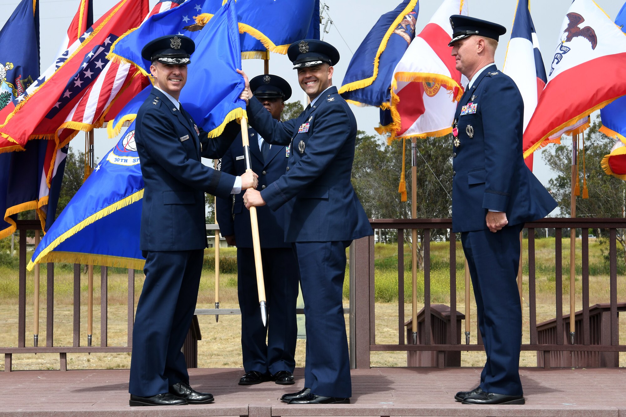 Maj. Gen. Stephen N. Whiting, 14th Air Force commander and Joint Force Space Component Command deputy commander, presents the 30th Space Wing guidon to the incoming 30th SW commander, Col. Anthony J. Mastalir, during a change of command ceremony July 12, 2019, at Vandenberg Air Force Base, Calif.