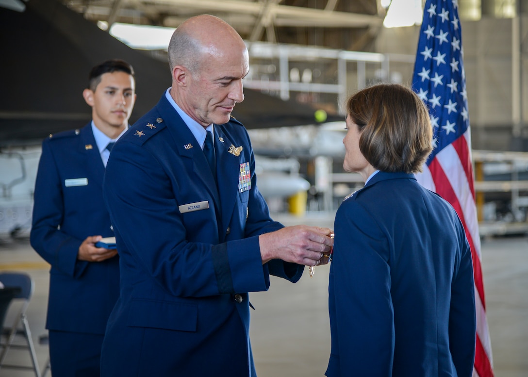 Maj. Gen. Christopher Azzano, Air Force Test Center Commander, places a Legion of Merit award on Col. Angela Suplisson, AFTC Vice Commander, during her retirement ceremony at Edwards Air Force Base, California, July 12. (U.S. Air Force photo by Giancarlo Casem)