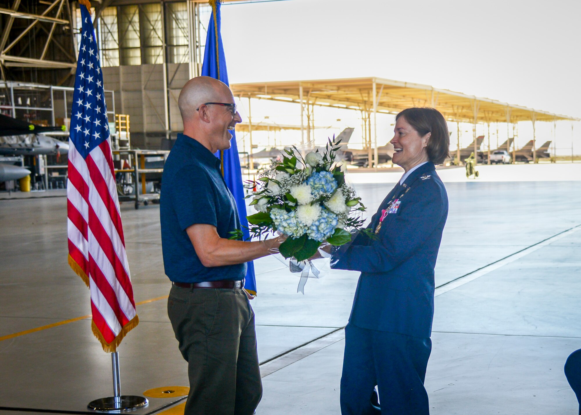 Fabrice Suplisson presents his wife, Col. Angela Suplisson, Air Force Test Center Vice Commander, a bouquet of flowers during her retirement ceremony at Edwards Air Force Base, California, July 12. Suplisson retired after 28 years of service. (U.S. Air Force photo by Giancarlo Casem