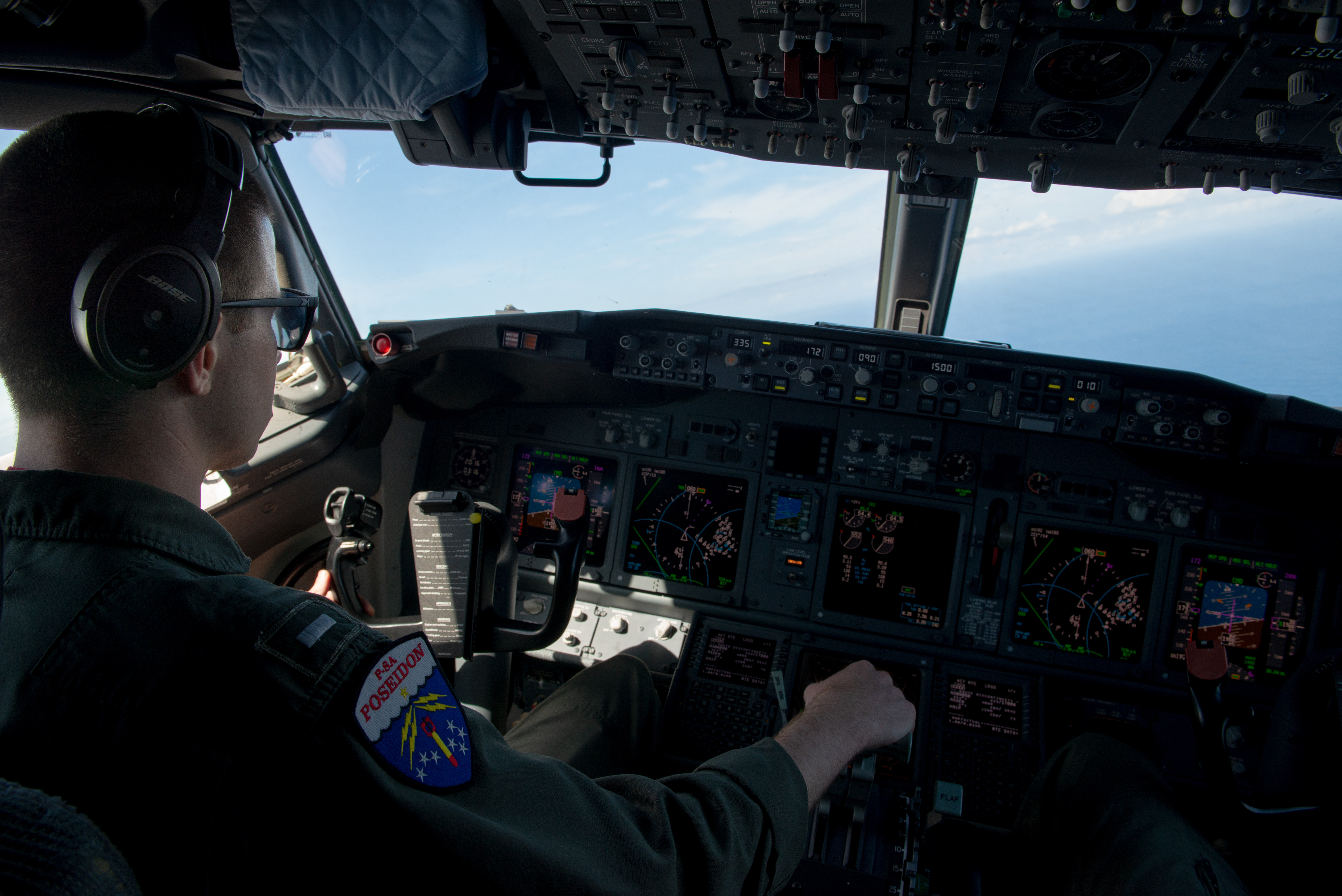A man with his hand on the throttle inside a P8-A aircraft