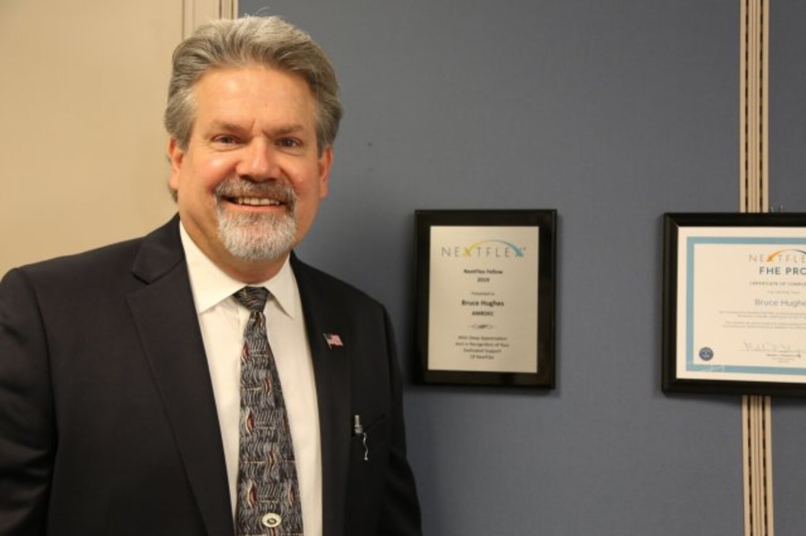 Bruce Hughes, U.S. Army Combat Capabilities Development Command Aviation & Missile Center Engineering Directorate electronics engineer and subject matter expert, poses next to a plaque commemorating his induction as a NextFlex fellow at Redstone Arsenal on May 2. (Photo Credit: Joanna Bradley)