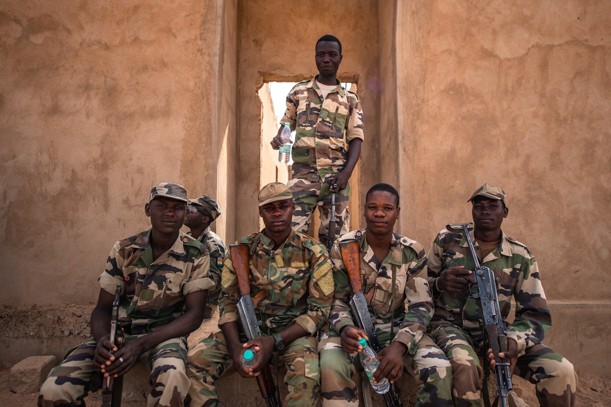 Niger Armed Forces (French language: Forces Armées Nigeriennes) members take a break during a training exercise with the 409th Expeditionary Security Forces Squadron air advisors at the FAN compound on Nigerien Air Base 201 in Agadez, Niger, July 10, 2019. The air advisors train the FAN on a daily basis, increasing their readiness and improving interoperability. (U.S. Air Force photo by Staff Sgt. Devin Boyer)