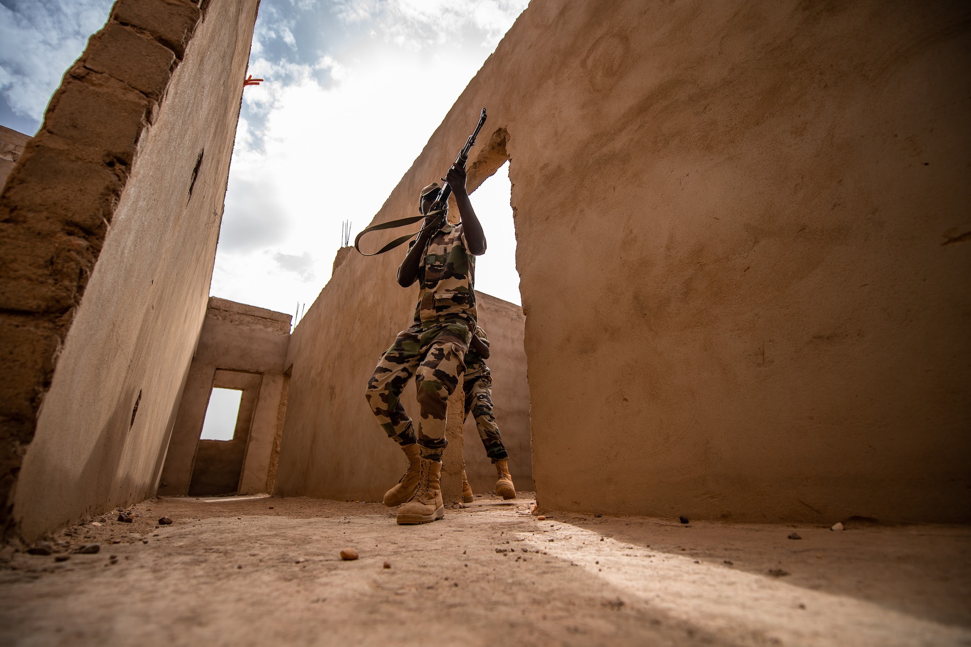 A Niger Armed Forces (French language: Forces Armées Nigeriennes) member clears a corridor during a training exercise with the 409th Expeditionary Security Forces Squadron air advisors at the FAN compound on Nigerien Air Base 201 in Agadez, Niger, July 10, 2019. The air advisors taught them how to efficiently clear a building while keeping their comrades safe. (U.S. Air Force photo by Staff Sgt. Devin Boyer)