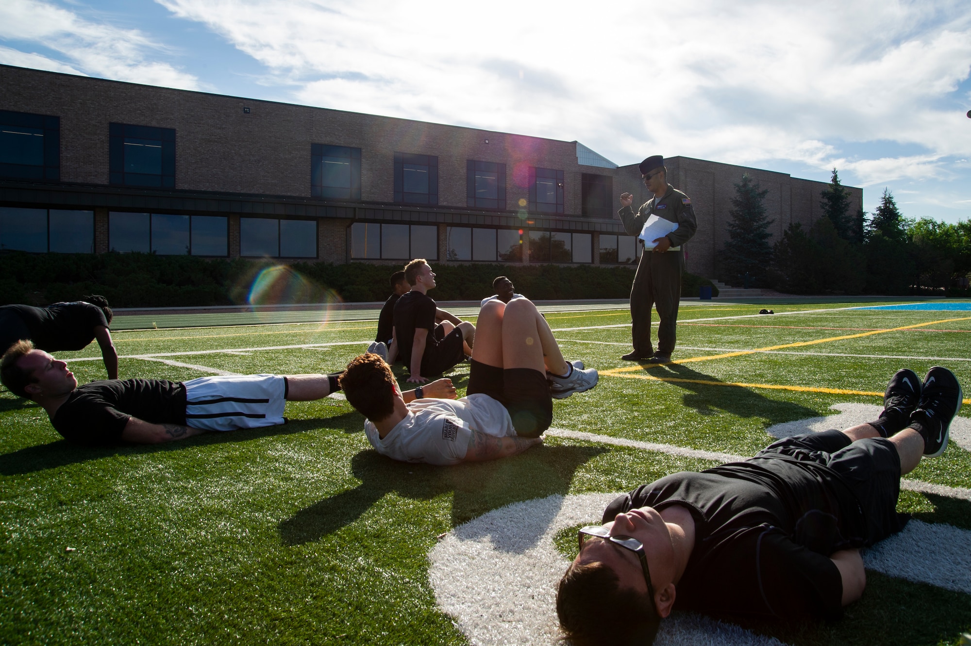 Tech. Sgt. Joshua Winn, 302nd Airlift Wing Development and Training Flight program manager, supervises trainees during group physical fitness training July 14, 2019 at Peterson Air Force Base, Colorado. The D&TF program is designed to prepare future Reserve Citizen Airmen for Air Force basic military training. (U.S. Air Force photo by Tech. Sgt. Amber Sorsek)