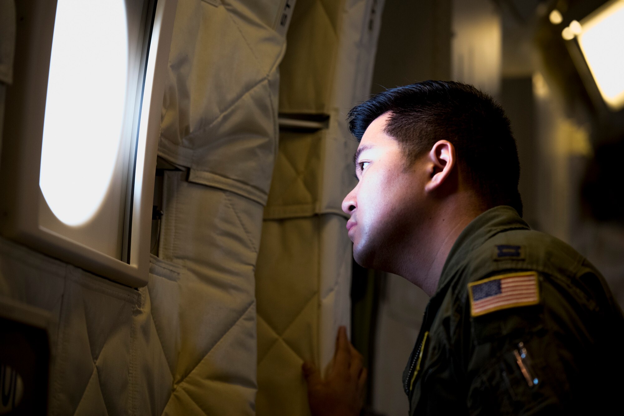 Capt. Terry Wu, 36th Airlift Squadron C-130J instructor pilot, looks out a window of a Japan Air Self- Defense Force C-2 during a bilateral airlift exchange over Chubu region, Japan, July 10, 2019.