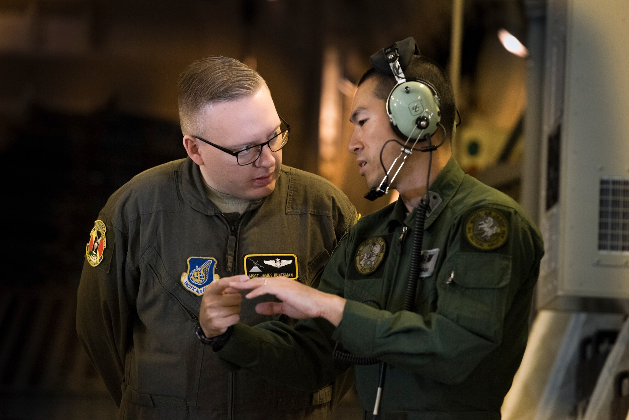 A member of the Japan Air Self-Defense Force answers questions from Master Sgt. James Huntsman, 36th Airlift Squadron flight chief and C-130J instructor loadmaster, during a bilateral airlift exchange over Chubu region, Japan, July 10, 2019.