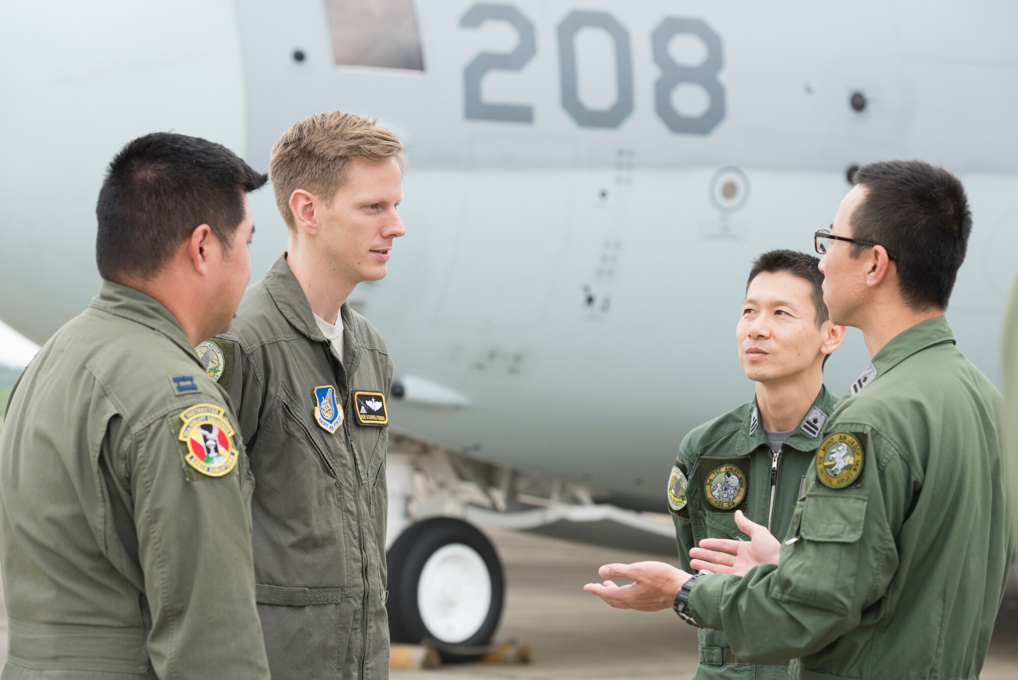 Capt. Benjamin Schimelfening, 36th Airlift Squadron C-130J instructor pilot and operation supervisor, converses with aircrew members from the Japan Air Self-Defense Force during a bilateral airlift exchange at Iruma Air Base, Japan, July 10, 2019.