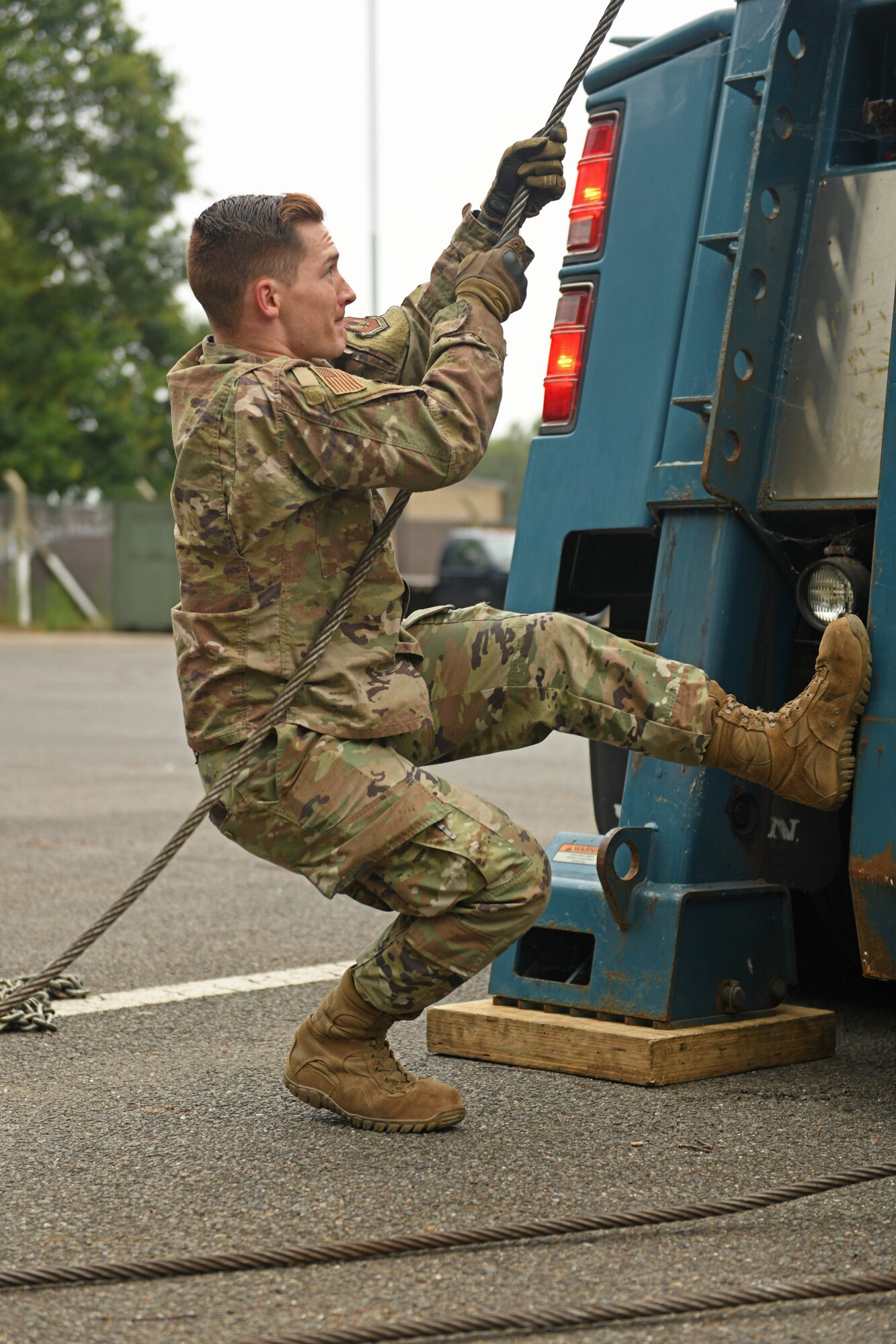U.S. Air Force Senior Airman Devin Needs, 100th Logistics Readiness Squadron ground transportation operator pulls a cable from a tow truck during a Readiness Honed In Operations training day at RAF Lakenheath, England, July 13, 2019. The training was the first dual-wing RHINO training day for ground transportation Airmen that encompassed expeditionary, contingency and specialty skills training such as basic expeditionary airfield resources base setup, integrated defense and vehicle recovery. (U.S. Air Force photo by Senior Airman Luke Milano)