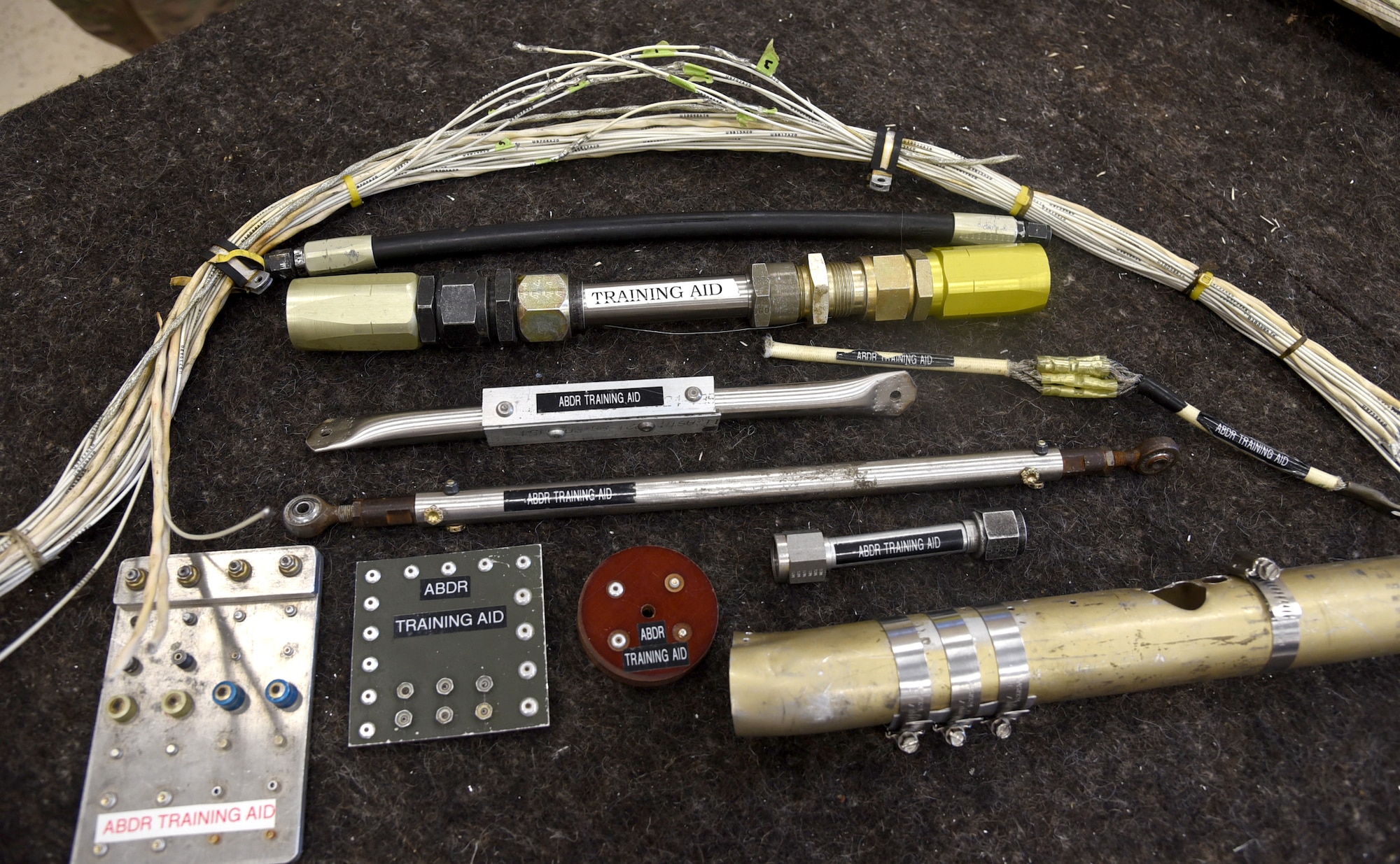 The 76th Aircraft Maintenance Group's Expeditionary Depot Maintenance section uses several training aids with Airmen learning aircraft battle damage repair. From patching sheetmetal to splicing wires, the Airmen benefit from their training while giong through their exercises, such as the CBRNE exercise June 24, where they had to repair the damaged aircraft while also dressed in MOPP 4 gear, utilizing their self-aid buddy care knowledge and doing post-attack reconnaissance sweeps to find any unexploded ordnance. (U.S. Air Force photo/Kelly White)