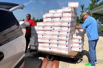 U.S. Army Sgt. Maj. Ronald Houston, U.S. Army Financial Management Command operations, left, and Mark Sullivan, USAFMCOM financial management systems analyst, right, load care packages into a van outside the Maj. Gen. Emmett J. Bean Federal Center, Indianapolis, June 29, 2019. USAFMCOM, Defense Finance and Accounting Service and Army Human Resources Command Soldiers and civilian employees volunteered their off-duty time to package and help ship more than 200 care packages to financial management service members currently deployed in Southwest Asia. (U.S. Army courtesy photo provided by Mark Sullivan, U.S. Army Financial Management Command)