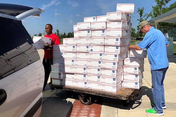 U.S. Army Sgt. Maj. Ronald Houston, U.S. Army Financial Management Command operations, left, and Mark Sullivan, USAFMCOM financial management systems analyst, right, load care packages into a van outside the Maj. Gen. Emmett J. Bean Federal Center, Indianapolis, June 29, 2019. USAFMCOM, Defense Finance and Accounting Service and Army Human Resources Command Soldiers and civilian employees volunteered their off-duty time to package and help ship more than 200 care packages to financial management service members currently deployed in Southwest Asia. (U.S. Army courtesy photo provided by Mark Sullivan, U.S. Army Financial Management Command)