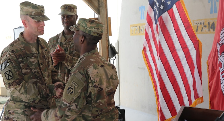 Col. Chris Becking, Afghanistan District Commanding Officer shakes the hand of outgoing commander, Col. Jason E. Kelly following the Change of Command Ceremony at Bagram Airfield July 15.