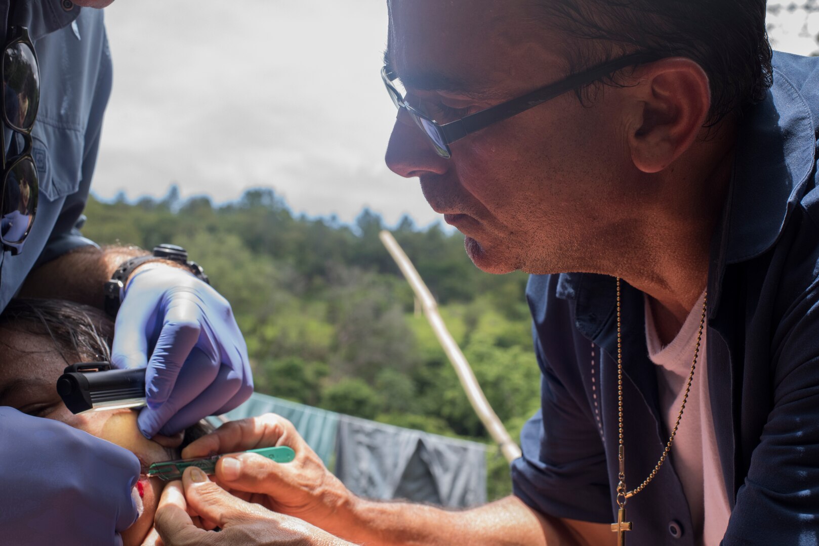 U.S. Army Lt. Col. Manuel Pouparina, Joint Task Force – Bravo Medical Element physician, takes a tissue sample from a Honduran woman whom contracted Leishmaniasis, during an investigation, July 9, 2019, at La Libertad, Honduras. Members of JTF-B were asked by the Honduran Ministry of Health to conduct an investigation into the cause of Leishmaniasis and provide any recommendations that may stop infection. Leishmaniasis is a parasitic disease that is caused by infection with leishmania parasites, which are spread through the bite of sand flies. (U.S. Air Force photo by Staff Sgt. Eric Summers Jr.)