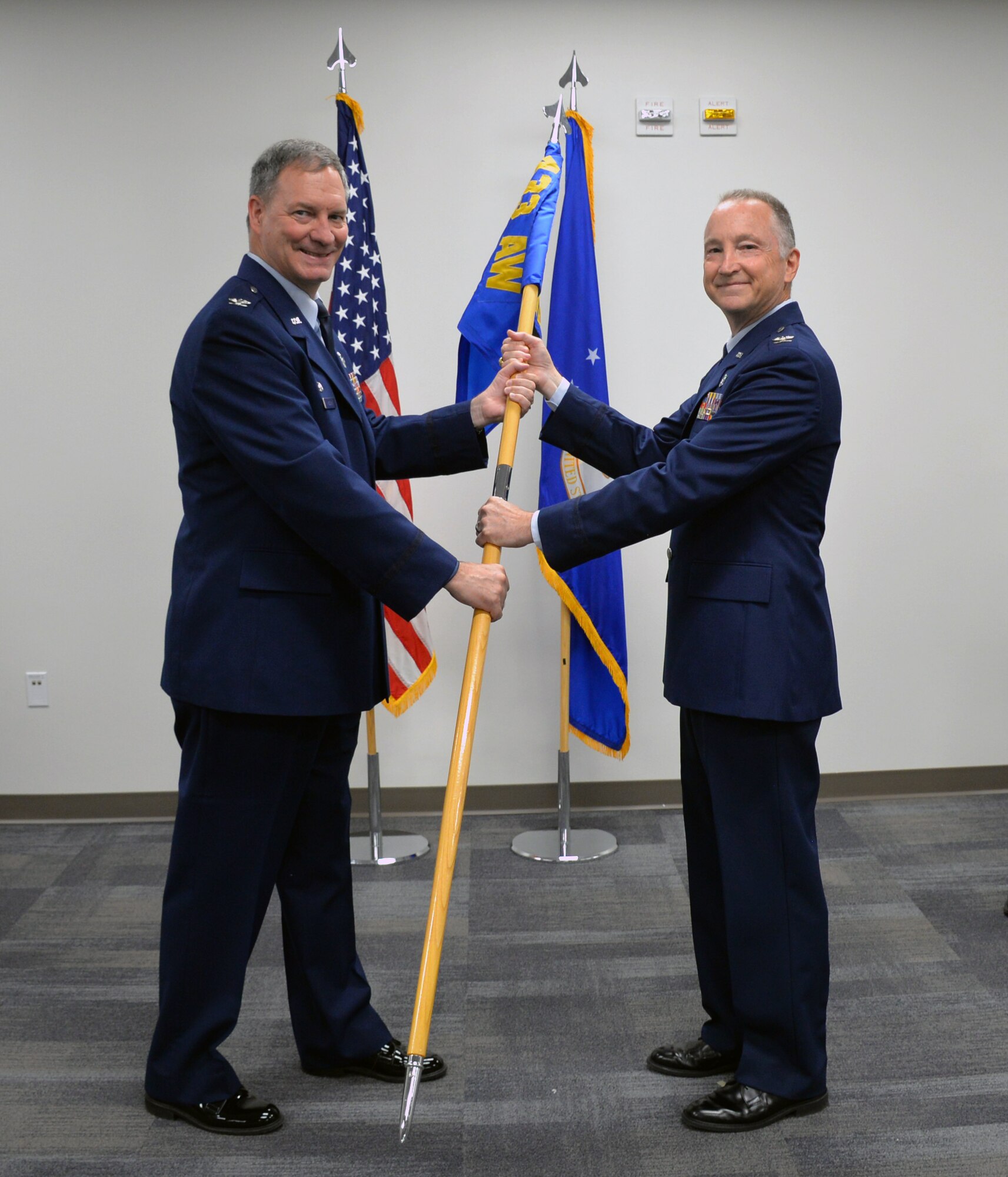 Col. Terry W. McClain, 433rd Airlift Wing commander, passes the 433rd Medical Group guidon to Col. Michael C. Brice to signify the assumption of command during a ceremony July 13, 2019 at Joint Base San Antonio-Lackland, Texas.