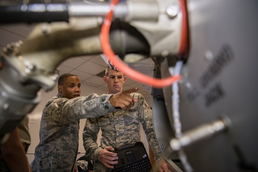 Staff Sgt. Carnell Robinson, left, an instructor assigned to the 373rd Training Squadron, points to the internal components of an avionic fuel systems simulator during a demonstration for a student, Airman 1st Class Eric Trammel, July 1, 2019, at Detachment 5, Joint Base Charleston, S.C. Detachment 5 utilizes a 44,000 square foot maintenance training facility to safely and effectively train Mobility Airmen throughout the Air Force on maintenance and repair procedures. The instructor team provides over 20,000 hours of instruction per year to new and seasoned avionic maintainers of the U.S. and partnered militaries who also utilize similar airframes. The Airmen are trained on innovative simulators in a safety oriented environment to maximize their effectiveness on the flightline. The C-17 Maintenance Trainer Development Team is comprised of training instructors from multiple Air Force Specialty Codes who fill the role as subject matter experts for the development of maintenance Airmen.