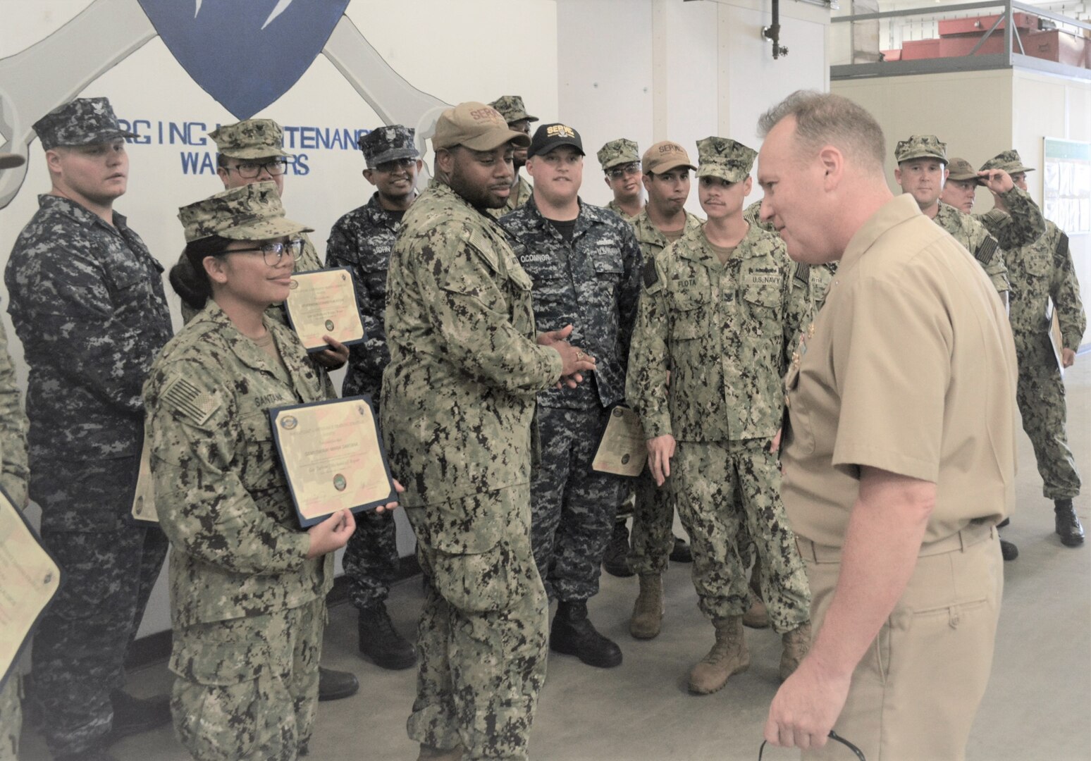 Rear Adm. Tom Anderson (right) congratulates GSM1 Maria Santana for her recently completed NAMTS qualification.