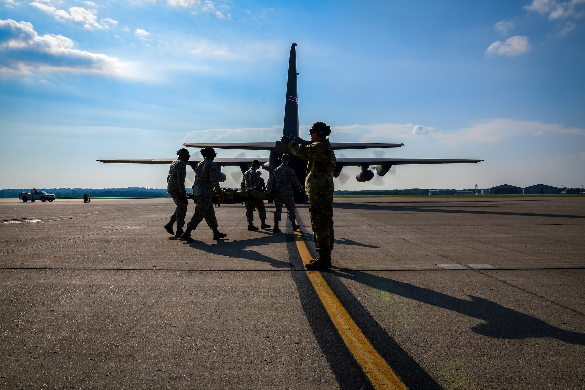 Reserve Citizen Airmen with the 445th Aeromedical Evacuation Squadron walk toward a Youngstown Air Reserve Station C-130H Hercules on July 10, 2019, on the flightline at Wright-Patterson Air Force Base.