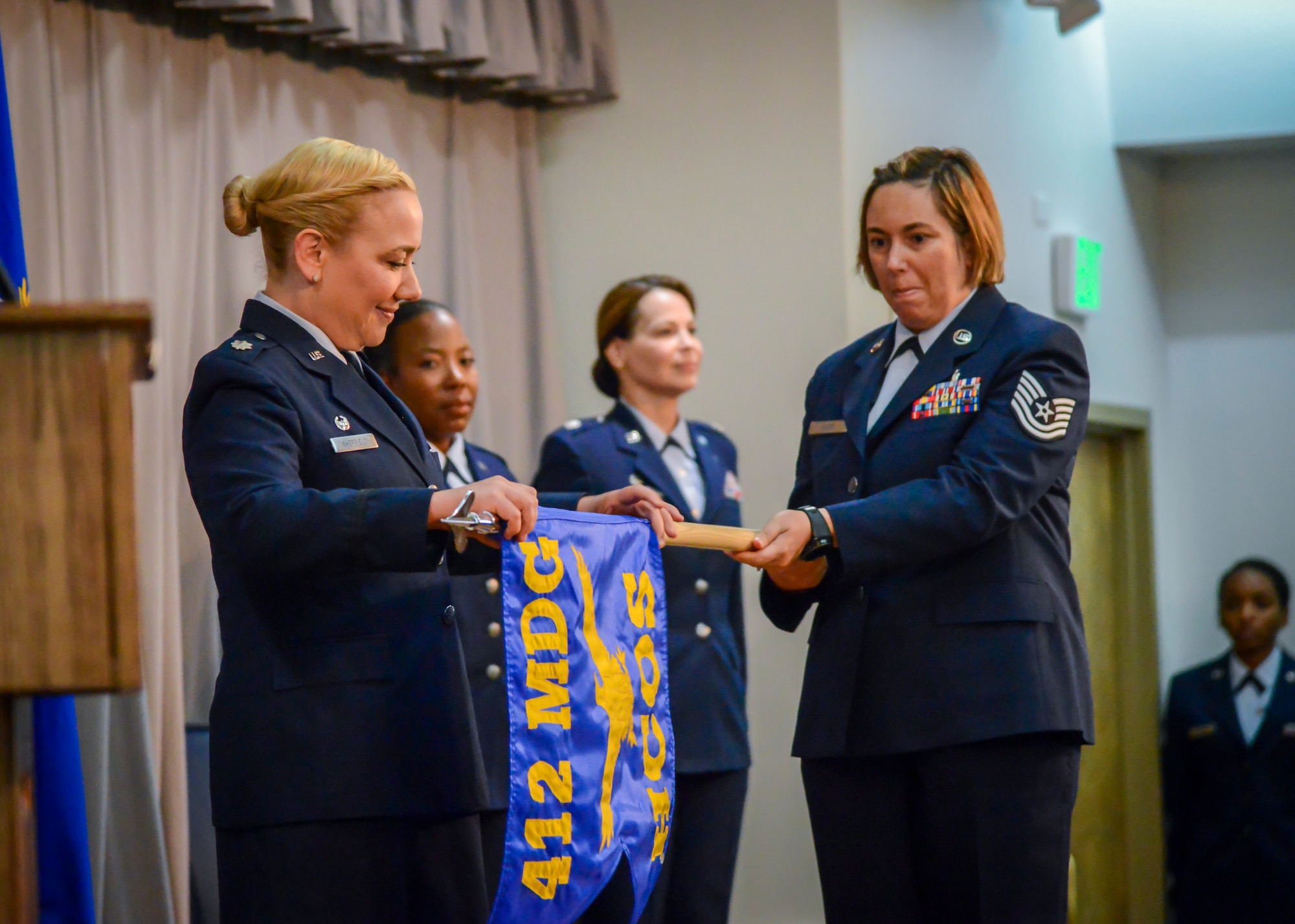 Lt. Col. Jennie Sheffield, the new 412th Health Care Operations Squadron Commander, unfurls the new unit’s guidon during an inactivation and redesgination ceremony at Edwards Air Force Base, July 12. The 412th Medical Support Squadron was inactivated its Airmen moved to the 412th Medical Operations Squadron which was then redesignated as the 412th Health Care Operations Squadron. (U.S. Air Force photo by Giancarlo Casem)