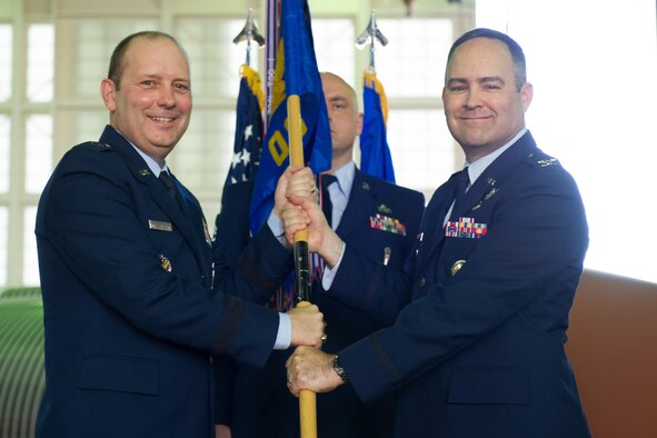 Brig. Gen. Douglas Schiess, 45th Space Wing commander, presents Col. Mark Shoemaker, incoming 45th Operations Group commander, with the 45th OG guidon as he assumes command of the group. (U.S. Air Force photo by Amanda Ryrholm)