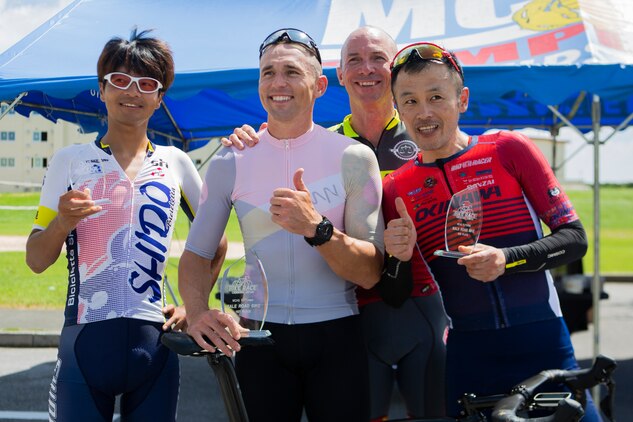 U.S. Marine Corps Col. David Steele, commanding officer of MCAS Futenma, poses for a photo with the top three competitors of the 2019 Futenma Bike Race on Marine Corps Air Station Futenma, Okinawa, Japan, July 14, 2019. The race invites Status of Forces Agreement personnel and the local Okinawan community to compete in race on and around MCAS Futenma’s airfield.