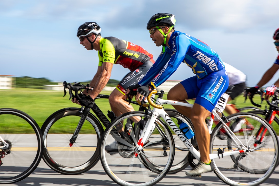 U.S. Marine Corps Col. David Steele, commanding officer of MCAS Futenma, competes to take the lead against a group of local Okinawan cyclists on Marine Corps Air Station Futenma, Okinawa, Japan, July 14, 2019. Cyclists were attending the 2019 Futenma Bike Race; a competition that invites Status of Forces Agreement personnel and the local Okinawan community to compete on and around MCAS Futenma’s airfield.