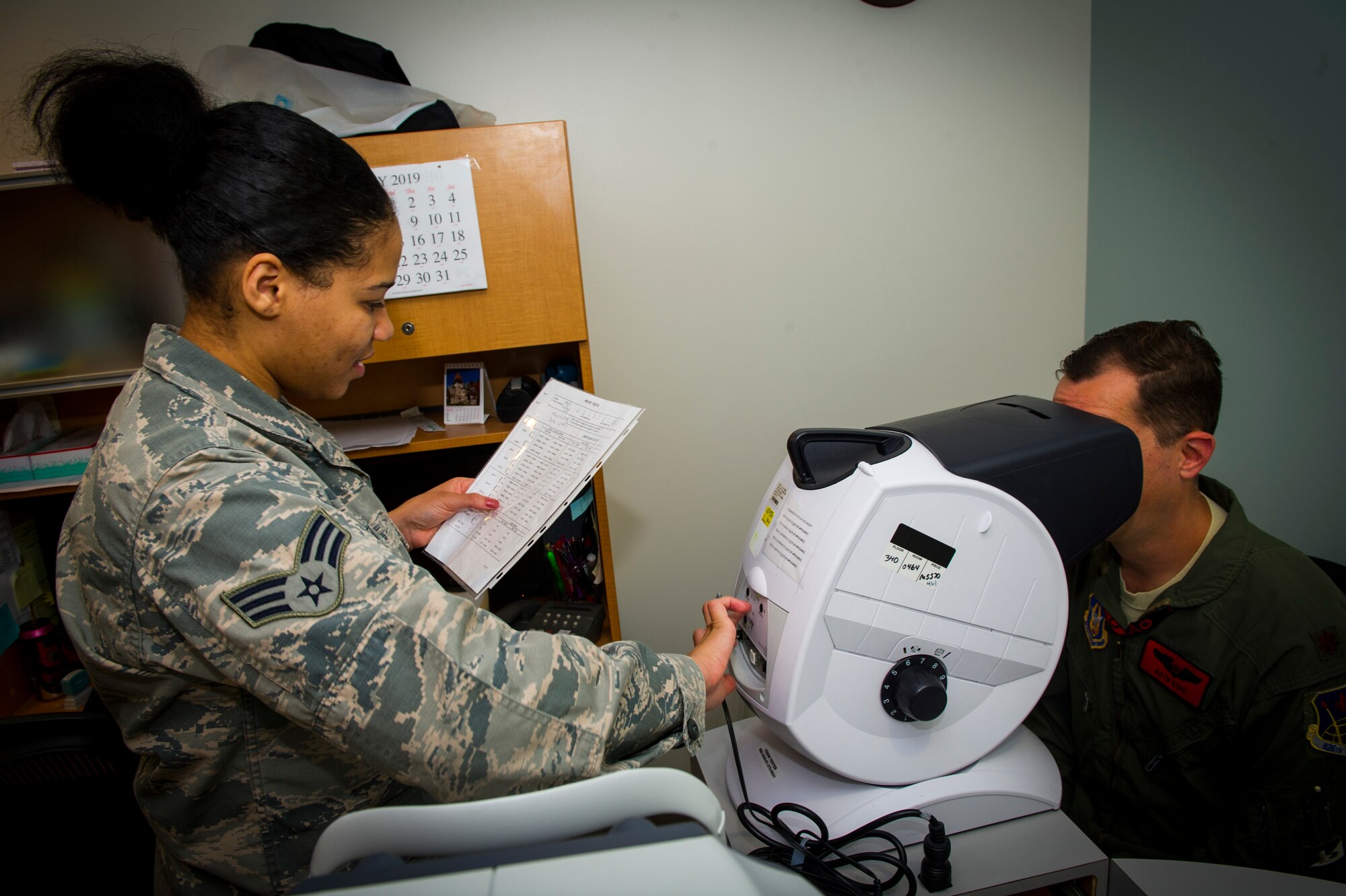 U.S. Air Force Senior Airman Rayne Patton, 926th Aerospace Medicine Squadron optical technician, reads a visual chart to a patient inside the medical clinic, July 13, 2019 at Nellis Air Force Base, Nev. The 926 AMDS works cohesively to ensure all Reserve personnel assigned are medically and operationally ready to fulfill the wing's mission. (U.S. Air Force photo/Senior Airman Brett Clashman)