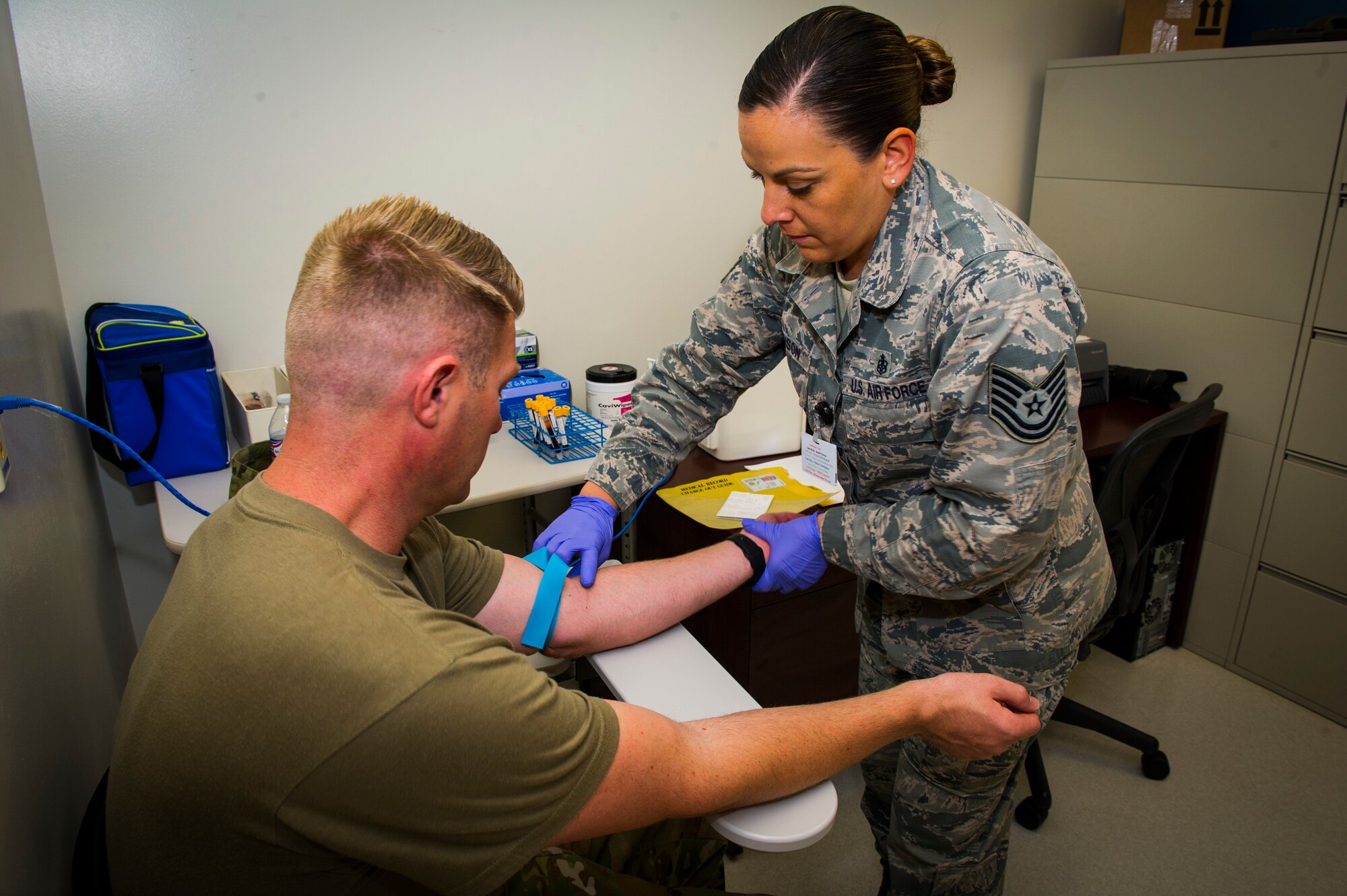 U.S. Air Force Tech Sgt. Leslie Robinson, 926th Aerospace Medicine Squadron medical lab technician, preps Master Sgt. Nicholas Hicks, 926th Aircraft Maintenance Squadron viper aircraft maintenace unit flight chief, to have blood drawn inside the medical clinic, July 13, 2019 at Nellis Air Force Base, Nev.