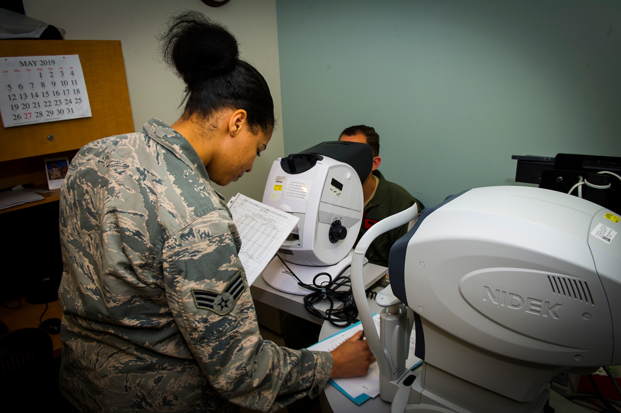 U.S. Air Force Senior Airman Rayne Patton, 926th Aerospace Medicine Squadron optical technician, reads a visual chart to a patient inside the medical clinic, July 13, 2019 at Nellis Air Force Base, Nev. The 926 AMDS provides direct medical support to Reserve Airmen to maintain operational readiness. (U.S. Air Force photo/Senior Airman Brett Clashman)