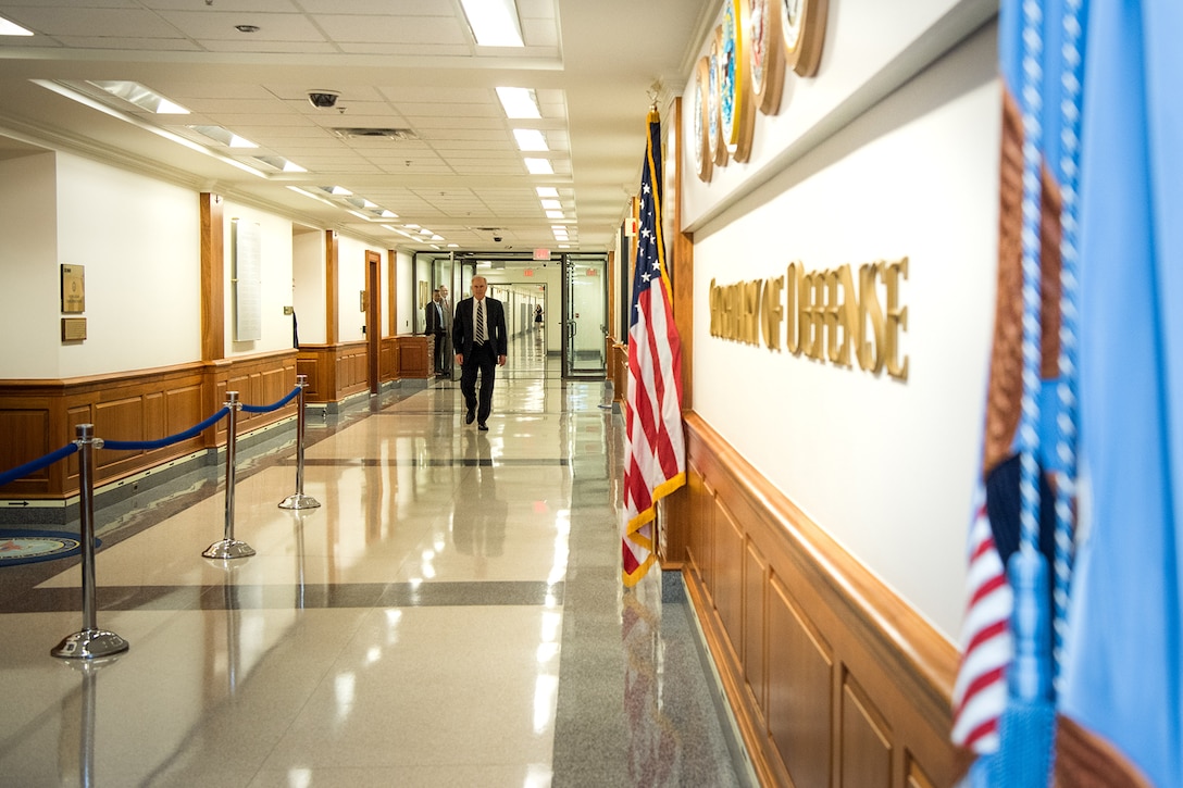 Acting Defense Secretary Richard V. Spencer walks down an empty hallway.